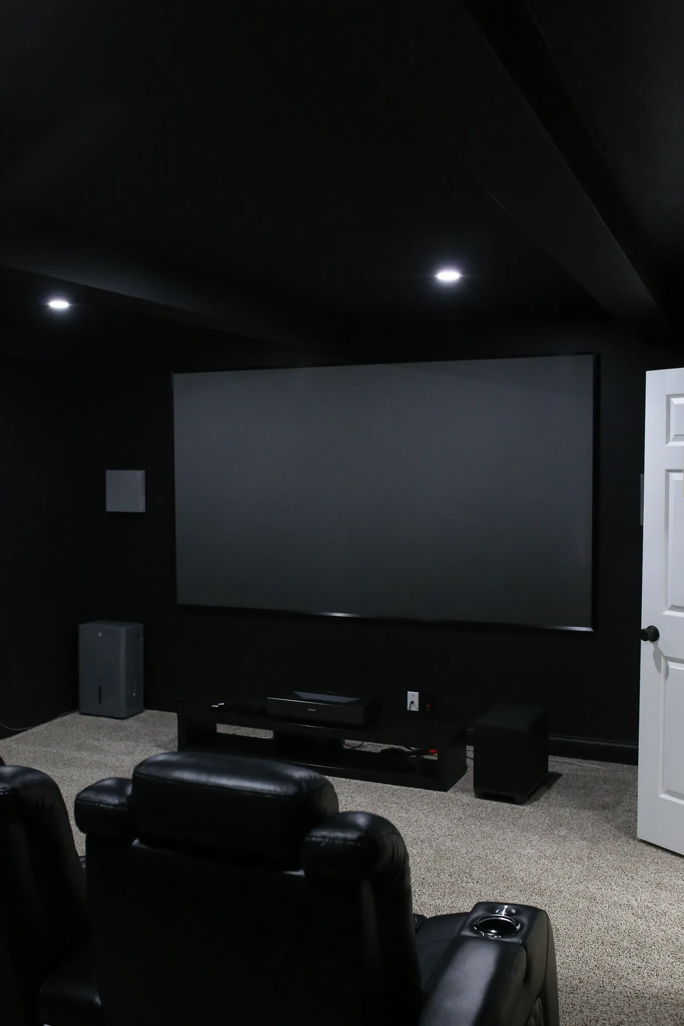 Basement wetbar with black cabinets and butcher block countertop